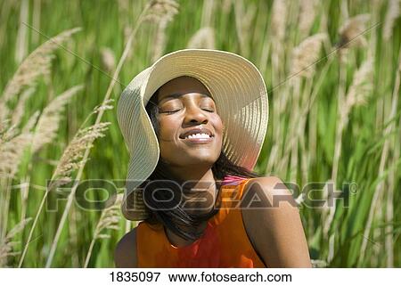 Woman in hat facing the sun View Large Photo Image Stock Photo - Woman in hat facing the sun. Fotosearch