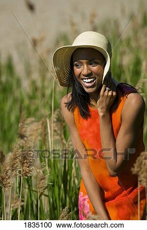 Woman in hat in tall grass View Large Photo Image Stock Image - Woman in hat in tall grass . Fotosearch