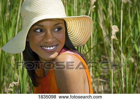 Stock Photo - Woman in hat in tall grass . Fotosearch