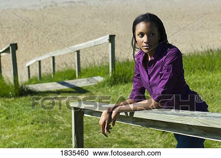 Stock Image - Woman leaning on fence. Fotosearch
