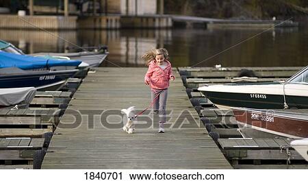 Stock Image - Woman running on the pier, Lake of the Woods, Ontario, Canada. Fotosearch