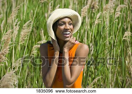 Woman wearing hat in tall grass View Large Photo Image Stock Photograph - Woman wearing hat in tall grass. Fotosearch