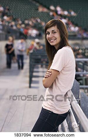 Picture - Young adult woman at a baseball game. Fotosearch