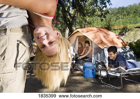 Stock Photo - Young adults at a camp site. Fotosearch