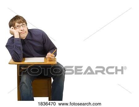 Stock Image - Young man in school desk. Fotosearch