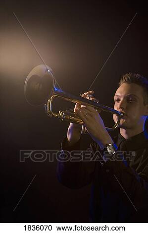 Stock Image - Young man playing a trumpet. Fotosearch