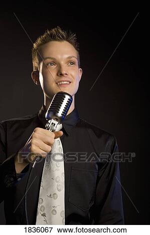 Young man with a microphone View Large Photo Image Stock Photo - Young man with a microphone. Fotosearch