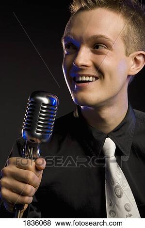Stock Photo - Young man with a microphone. Fotosearch