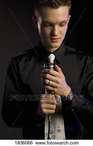 Young man with a microphone View Large Photo Image Stock Photograph - Young man with a microphone. Fotosearch