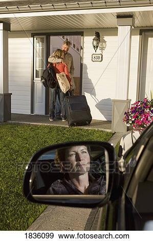 Stock Photo - Young woman visiting dad with mom looking on. Fotosearch