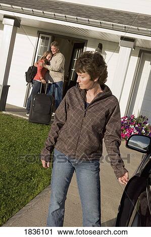 Stock Image - Young woman visiting dad with mother leaving. Fotosearch