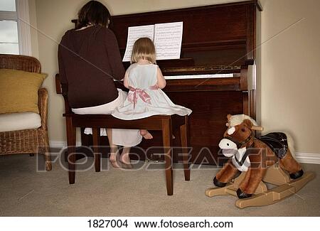 Picture - A woman and child playing piano. Fotosearch