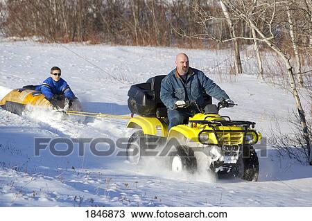 All-terrain vehicle pulling a tube View Large Photo Image Stock Image - All-terrain vehicle pulling a tube. Fotosearch