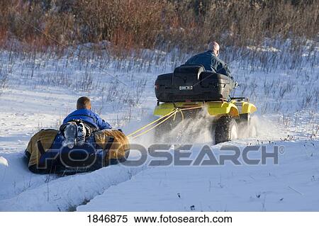 All-terrain vehicle pulling a tube View Large Photo Image Stock Photography - All-terrain vehicle pulling a tube. Fotosearch