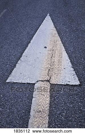 Stock Image - Arrow on road with tyre mark over it . Fotosearch