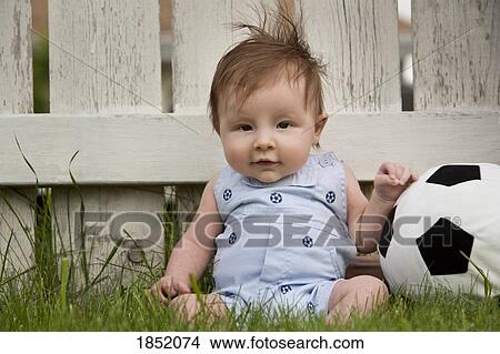 Baby boy; baby boy sitting in the grass with a soccer ball View Large Photo Image Picture - Baby boy; baby boy sitting in the grass with a soccer ball. Fotosearch