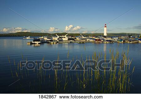 Stock Photo - Boats docked along a pier in a lake, Quebec, Canada. Fotosearch