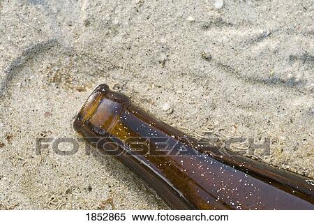 Stock Photography - Bottle; Beer bottle in the sand. Fotosearch