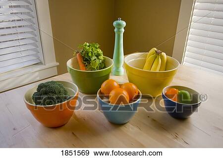 Stock Photo - Bowls with fruit and vegetables set on a table. Fotosearch