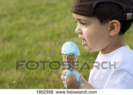 Stock Photo - Boy eating ice cream; Ice cream melting on boy's hand. Fotosearch