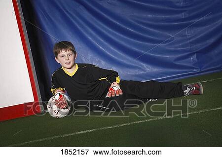 Stock Photo - Boy in soccer net. Fotosearch