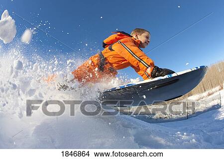 Picture - Boy on a sled; Child playing in the snow. Fotosearch
