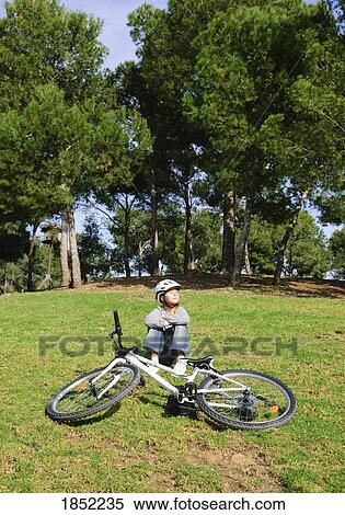 Boy sitting by his bike View Large Photo Image Stock Photography - Boy sitting by his bike. Fotosearch