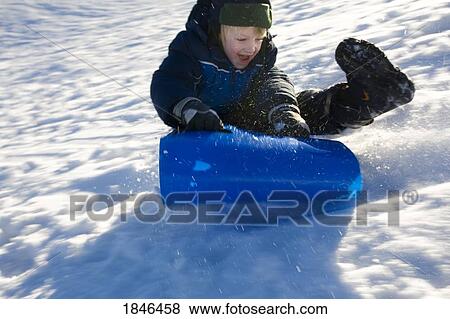 Stock Photo - Boy sledding. Fotosearch