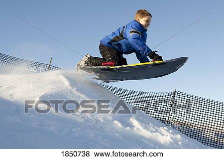 Stock Photo - Boy tobogganing. Fotosearch