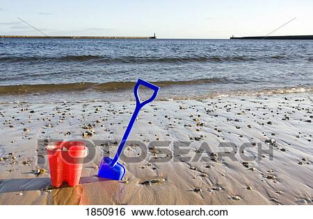 Stock Photograph - Bucket and shovel on beach. Fotosearch