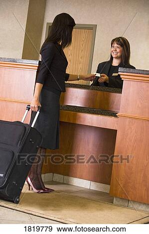Stock Photo - Businesswoman checking in at counter. Fotosearch