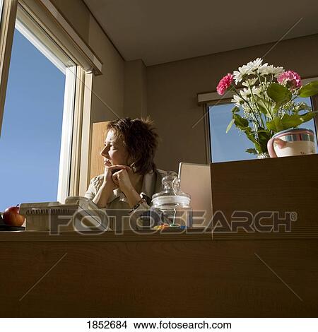 Picture - Businesswoman in office; Woman looking out the window. Fotosearch