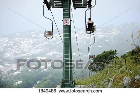 Capri, Italy; Woman riding chairlift to the top of Monte Solaro View Large Photo Image Stock Photograph - Capri, Italy; Woman riding chairlift to the top of Monte Solaro. Fotosearch