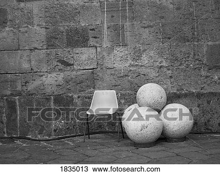 Stock Image - Chair, round rocks, Castle Nuovo, Naples, Italy . Fotosearch