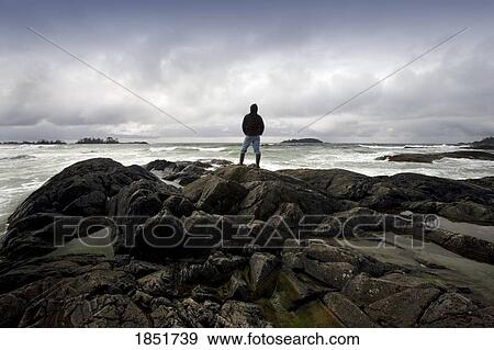 Stock Photo - Chesterman Beach, Tofino, Vancouver Island, British Columbia, Canada; man standing on the beach. Fotosearch