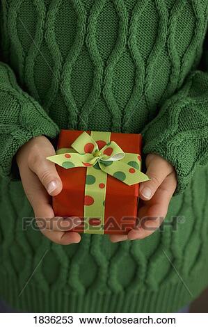 Stock Image - Child's hands holding a present. Fotosearch