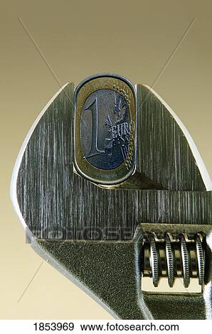 Close-up of wrench squeezing Euro coin View Large Photo Image Stock Photo - Close-up of wrench squeezing Euro coin. Fotosearch