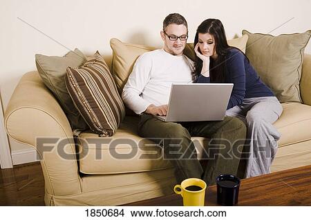 Couple looking at computer View Large Photo Image Picture - Couple looking at computer. Fotosearch