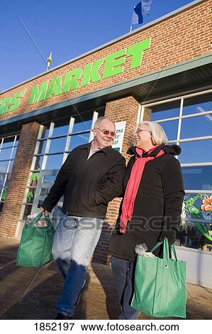 Stock Photo - Couple shopping together; Couple shopping at a farmer's market. Fotosearch