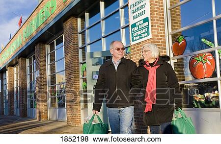 Stock Photo - Couple shopping together; Couple shopping at a farmer's market. Fotosearch
