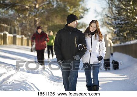 Stock Photograph - Couple walking on winter paths. Fotosearch