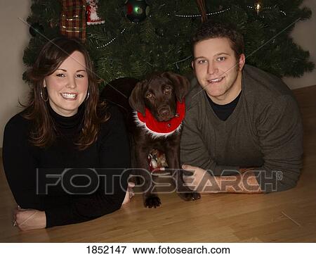 Stock Photo - Couple with dog; Couple with dog at Christmas. Fotosearch