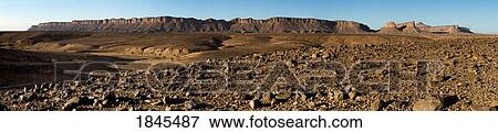 Stock Photo - Dry land below a mountain range. Fotosearch