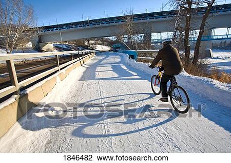 Stock Image - Edmonton, Alberta, Canada; Person riding a bike in the winter. Fotosearch