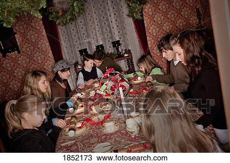 Stock Image - Family praying before Christmas dinner. Fotosearch