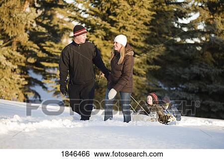 Stock Photograph - Family walking in the snow. Fotosearch