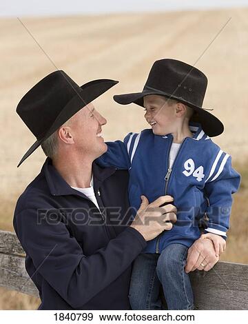 Stock Photo - Father and son; Man and his son wearing cowboy hats. Fotosearch
