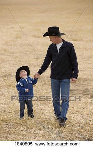 Stock Photography - Father and son; Man and his son wearing cowboy hats. Fotosearch