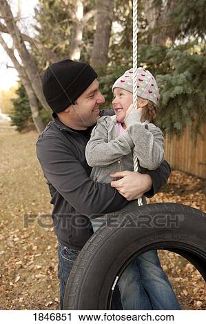 Father hugging daughter on tire swing View Large Photo Image Stock Image - Father hugging daughter on tire swing. Fotosearch