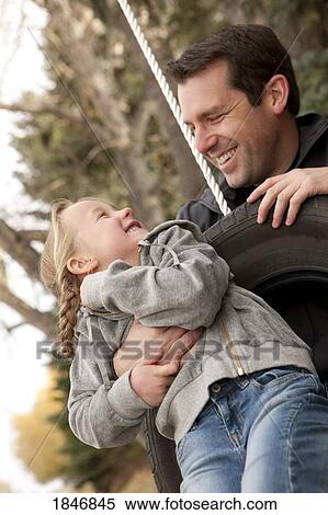 Father pushing daughter on tire swing View Large Photo Image Stock Photography - Father pushing daughter on tire swing. Fotosearch